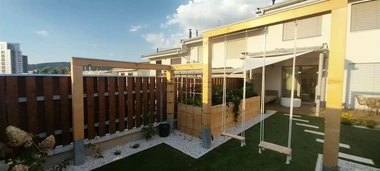 pohľad na realizáciu malej záhrady pri rodinnom dome s hojdačkami